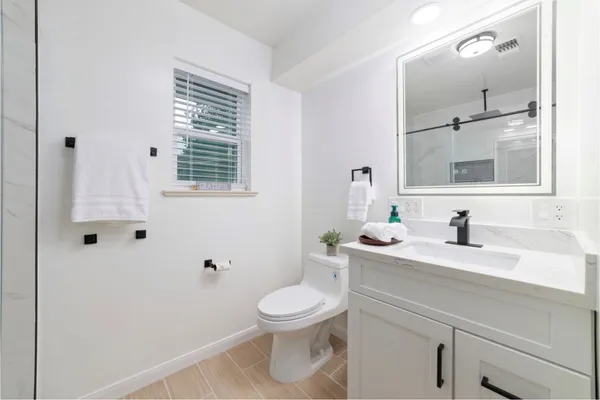 a bathroom with a toilet a sink and mirror