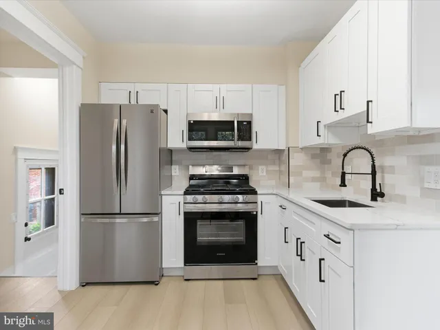 a kitchen with white cabinets and stainless steel appliances