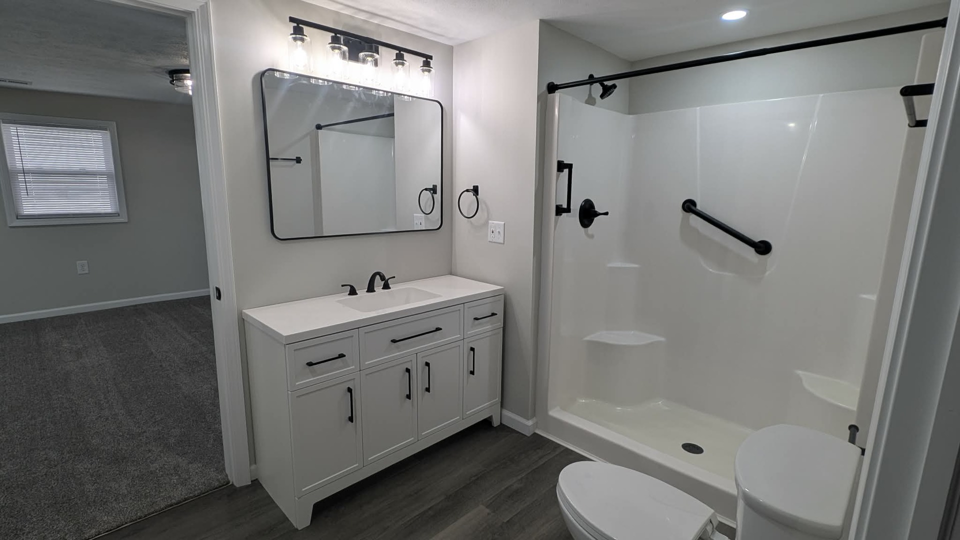 720 East Marion Street Clinton, IL 61727 - Photo 14 of 22 a bathroom with a double vanity sink toilet mirror and shower