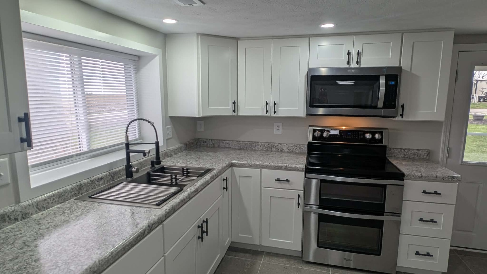 720 East Marion Street Clinton, IL 61727 - Photo 3 of 22 a kitchen with granite countertop a sink stainless steel appliances and cabinets
