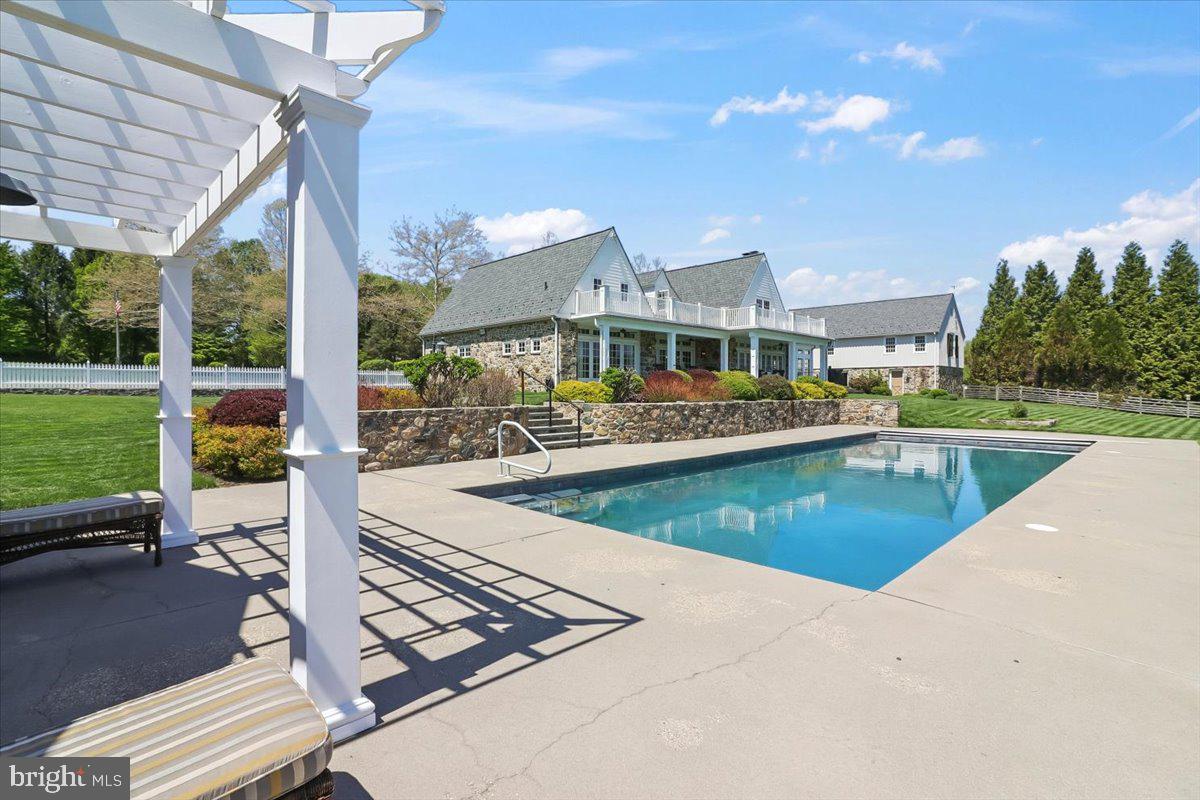 182 Trythall Road Elverson, PA 19520 - Photo 57 of 76 a view of a swimming pool with lawn chairs plants and large tree