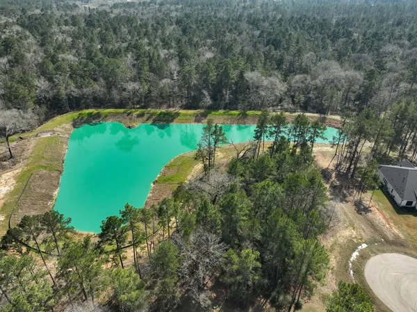 an aerial view of a house with a yard and lake view