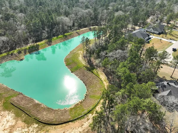 a view of a swimming pool with a yard and large trees