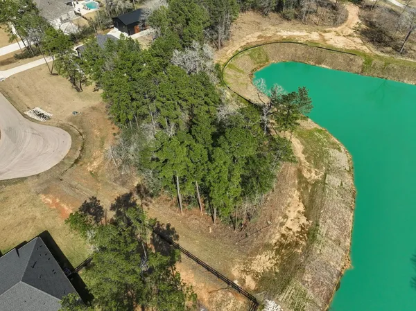 an aerial view of a house with a yard and lake view