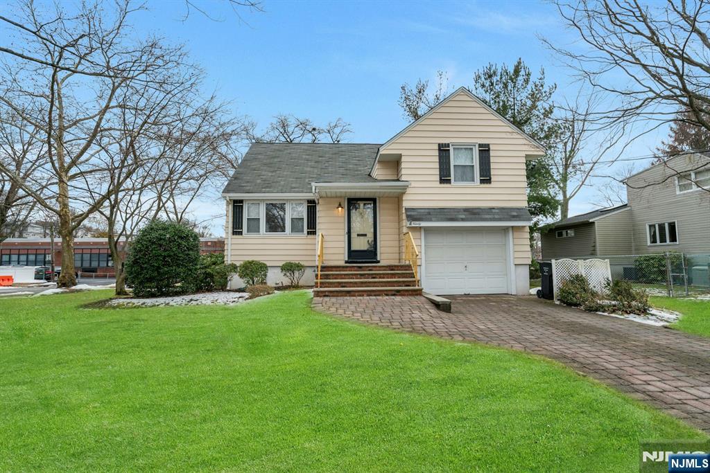 90 Arnot Place Paramus, NJ 07652 - Photo 23 of 32 a front view of a house with a yard and garage
