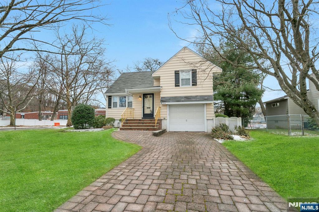 90 Arnot Place Paramus, NJ 07652 - Photo 25 of 32 a front view of a house with a garden and trees