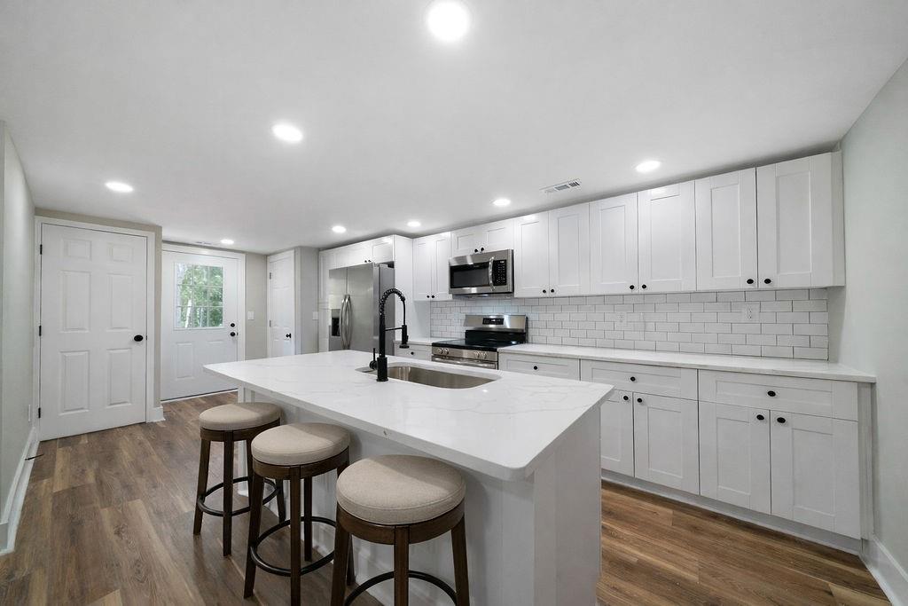 6488 Nebo Road Hiram, GA 30141 - Photo 11 of 32 a kitchen with kitchen island a stove a table and chairs in it