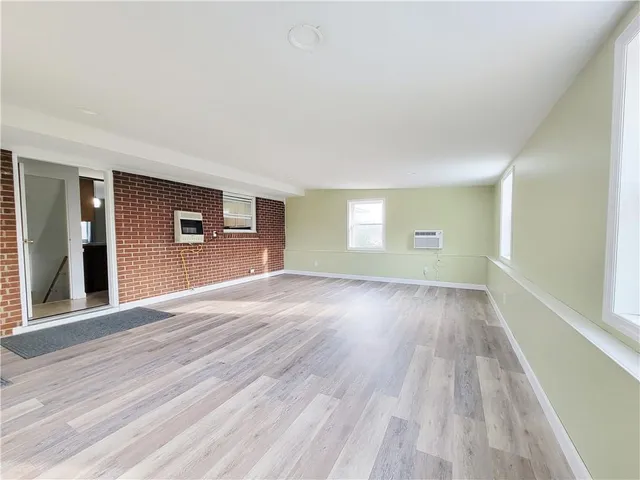 a view of empty room with kitchen and window