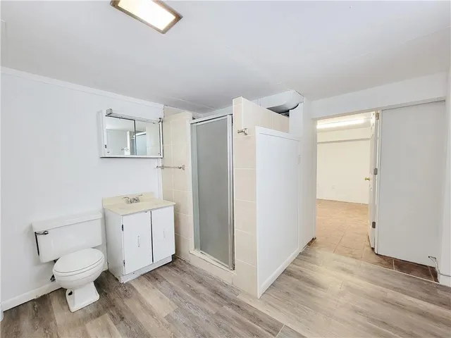 a very nice looking room with wooden floor and a ceiling fan