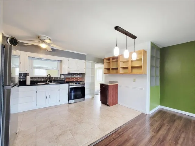 a kitchen with stainless steel appliances granite countertop a stove cabinets and wooden floor