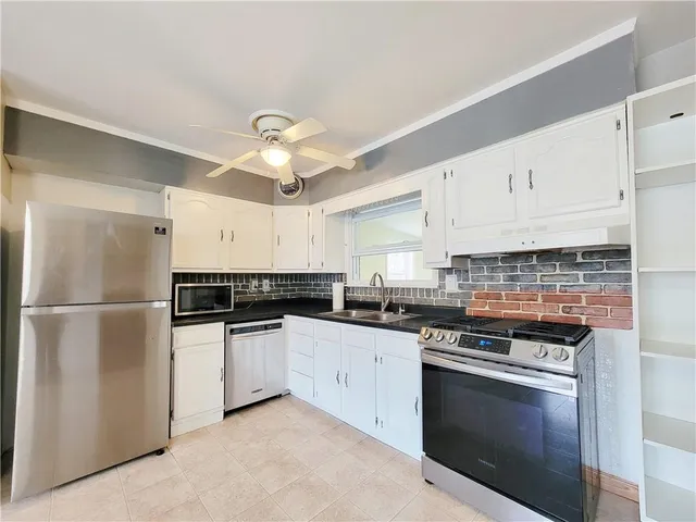 a kitchen with stainless steel appliances a stove a sink and a refrigerator