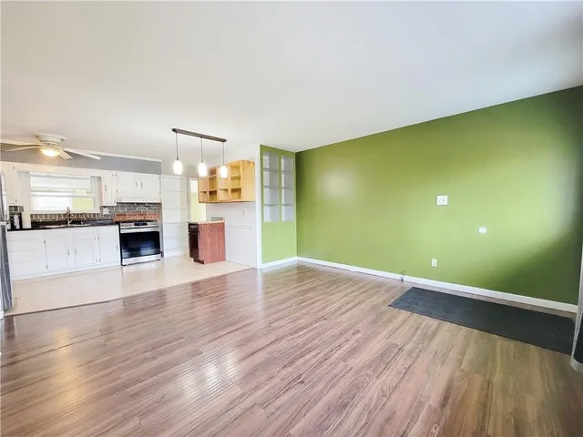a view of a living room with kitchen view and wooden floor