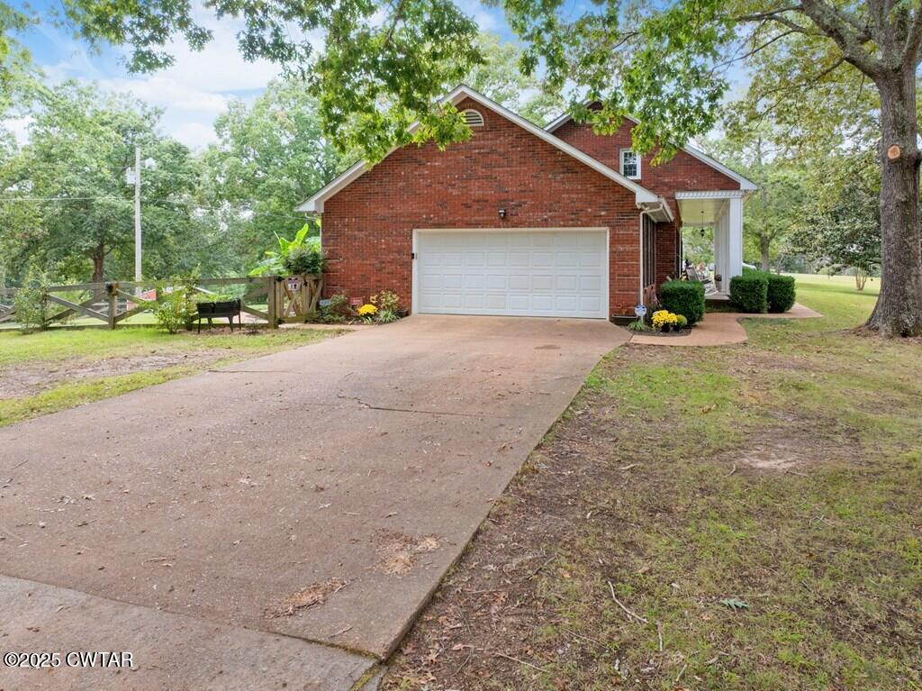 255 Hartley Road Camden, TN 38320 - Photo 12 of 79 a front view of a house with a yard and garage