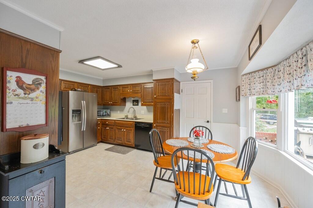 255 Hartley Road Camden, TN 38320 - Photo 32 of 79 a kitchen with stainless steel appliances granite countertop a stove a sink a dining table and chairs with wooden floor