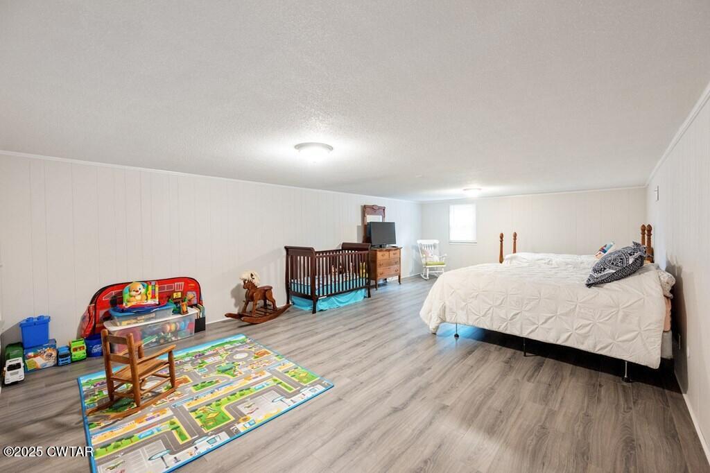 255 Hartley Road Camden, TN 38320 - Photo 42 of 79 a spacious bedroom with a bed a dresser and wooden floor