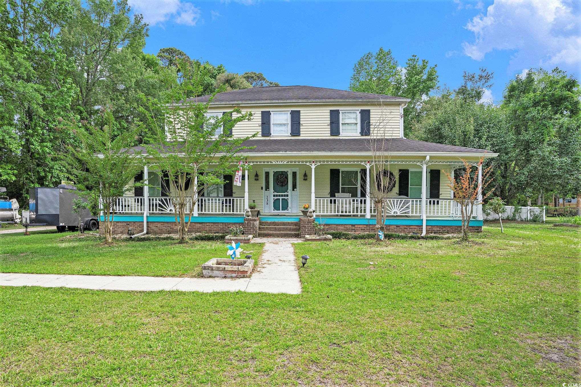 View of front of house with a porch and a front yard