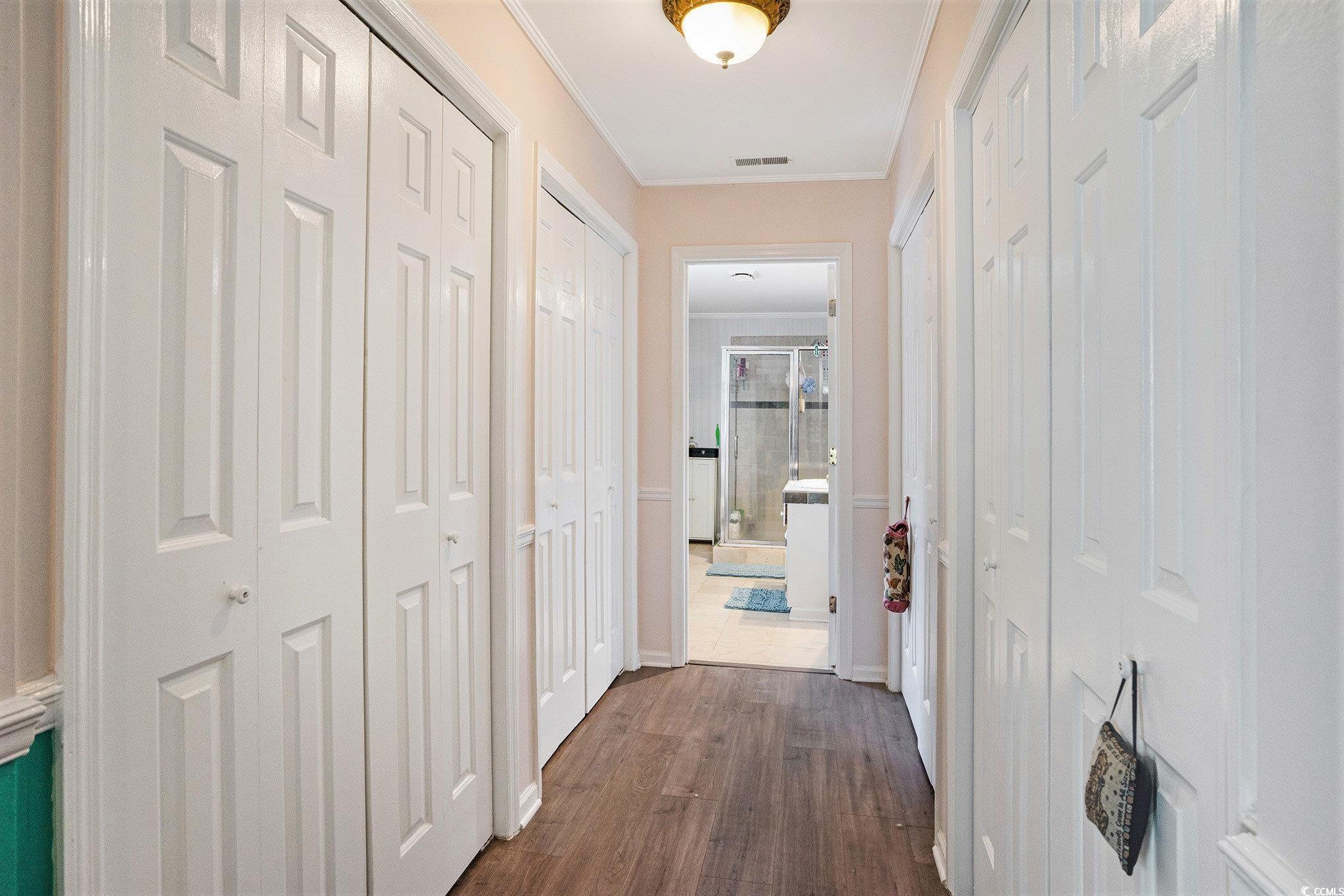 238 Robin Drive Georgetown, SC 29440 - Photo 21 of 31 Hallway featuring dark wood-style floors, baseboards, and crown molding