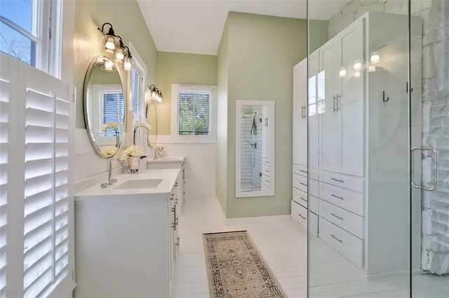 a bathroom with double vanity sink a two mirror and shower