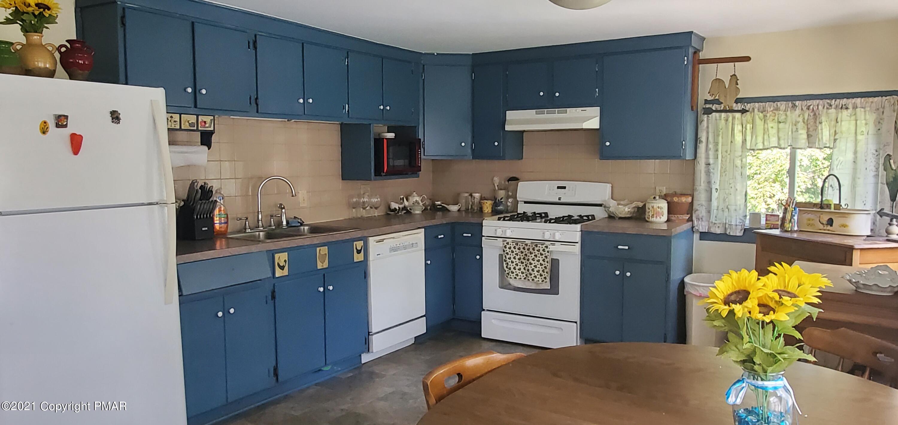 144 Merwinsburg Road Effort, PA 18330 - Photo 11 of 51 a kitchen with stainless steel appliances granite countertop a refrigerator a stove a sink dishwasher and white cabinets with wooden floor