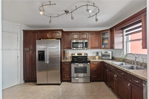 a kitchen with stainless steel appliances granite countertop a refrigerator a sink a stove and dishwasher