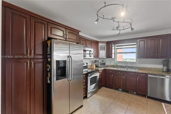 a kitchen with stainless steel appliances granite countertop a refrigerator and a sink