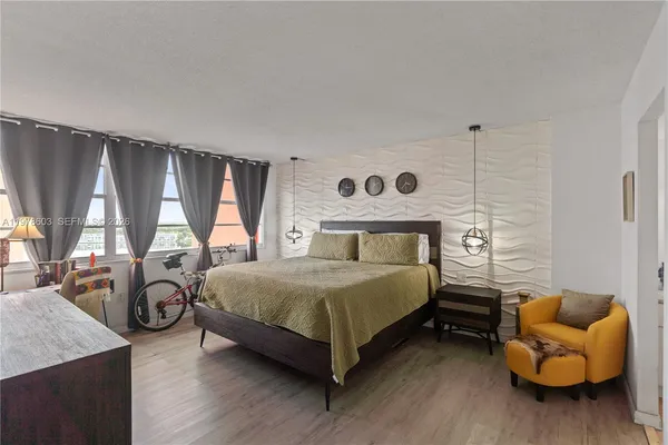 a bedroom with a bed and large windows