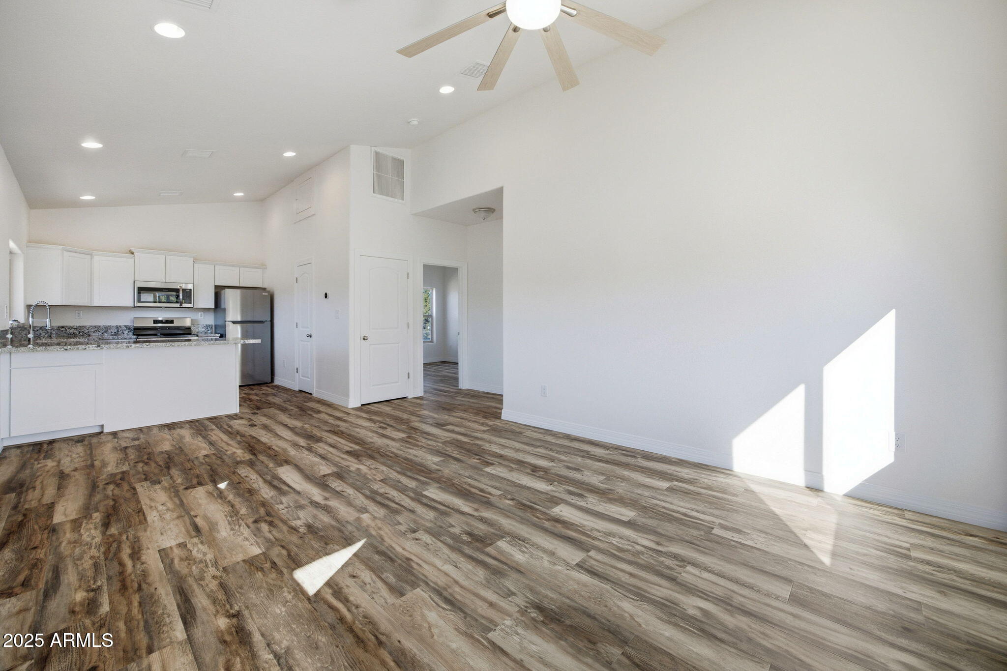 2224 Meadow Lane Overgaard, AZ 85933 - Photo 8 of 30 a view of a kitchen with kitchen island a sink wooden floor and a refrigerator
