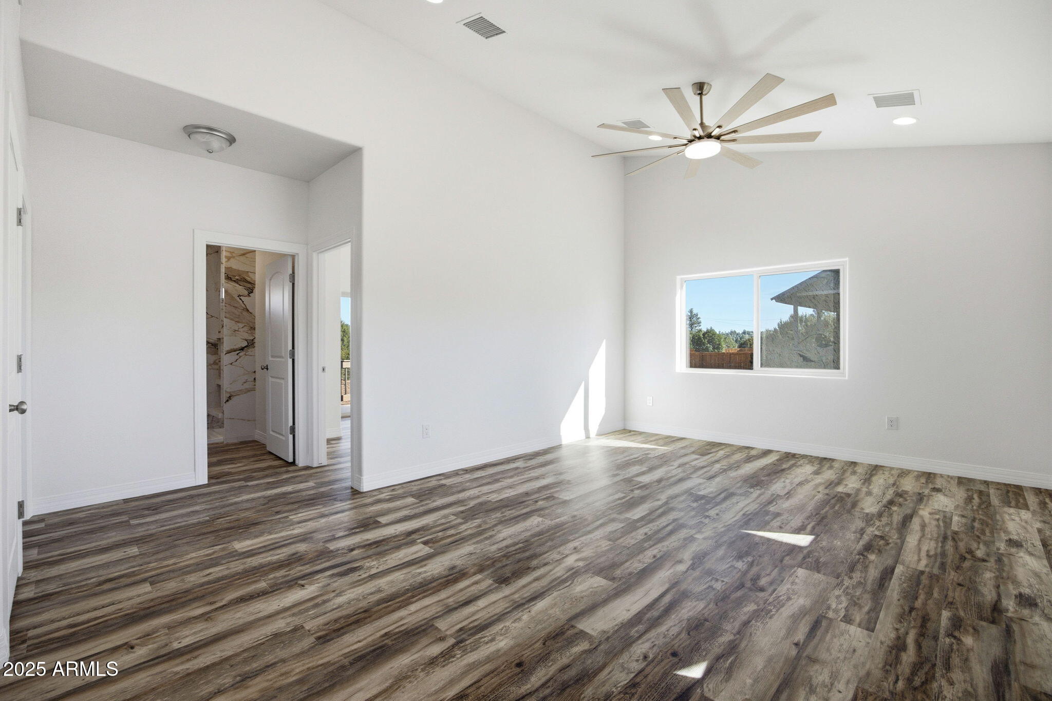 2224 Meadow Lane Overgaard, AZ 85933 - Photo 9 of 30 a view of an empty room with wooden floor and a window