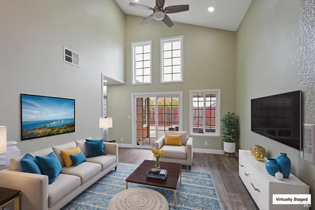 a living room with furniture floor to ceiling window and a flat screen tv