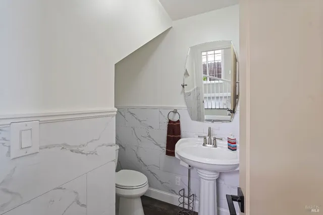 a bathroom with a sink toilet and a mirror