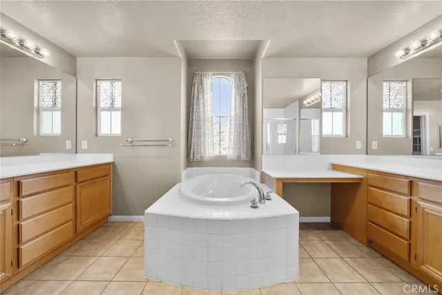 a spacious bathroom with a tub sink and mirror