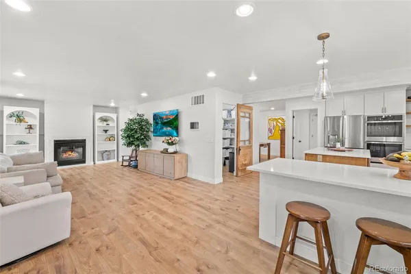 a living room with furniture a fireplace and a kitchen view
