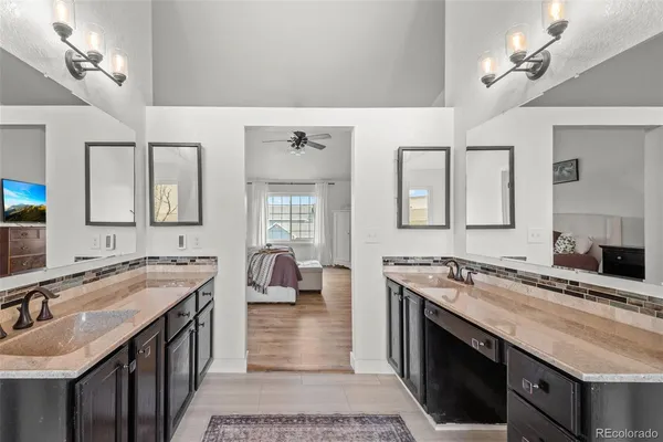 a spacious bathroom with a sink double vanity granite and a mirror