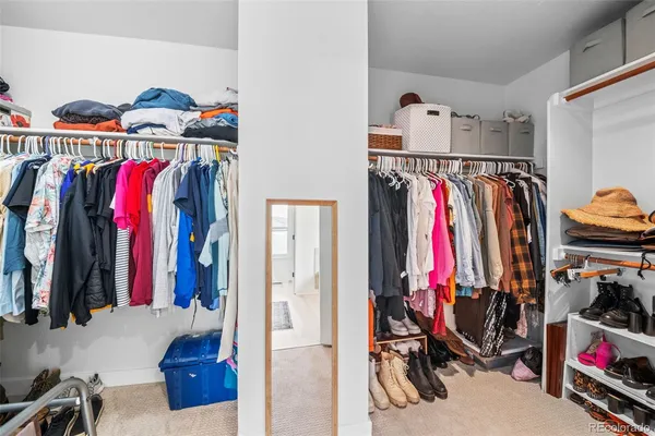 a view of walk in closet with clothes and shoes