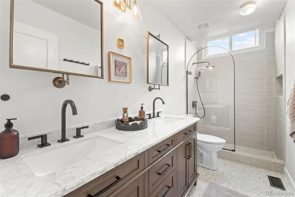 a bathroom with a double vanity sink toilet and shower