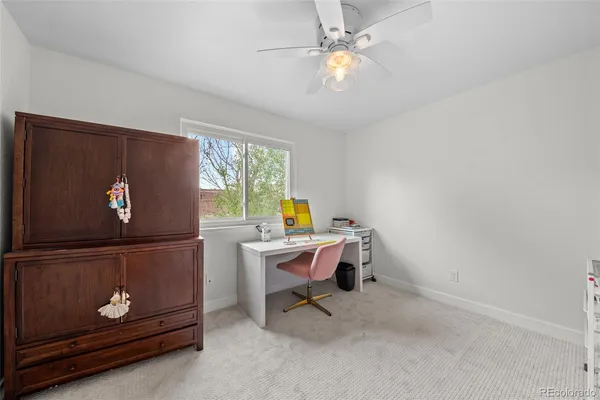 a view of a workspace with furniture and a window