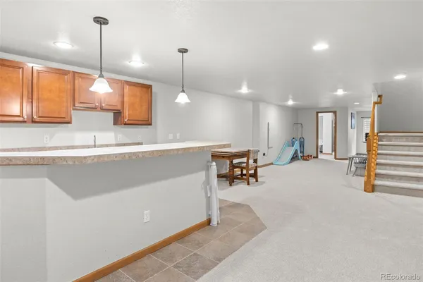a view of a kitchen with a sink and chairs