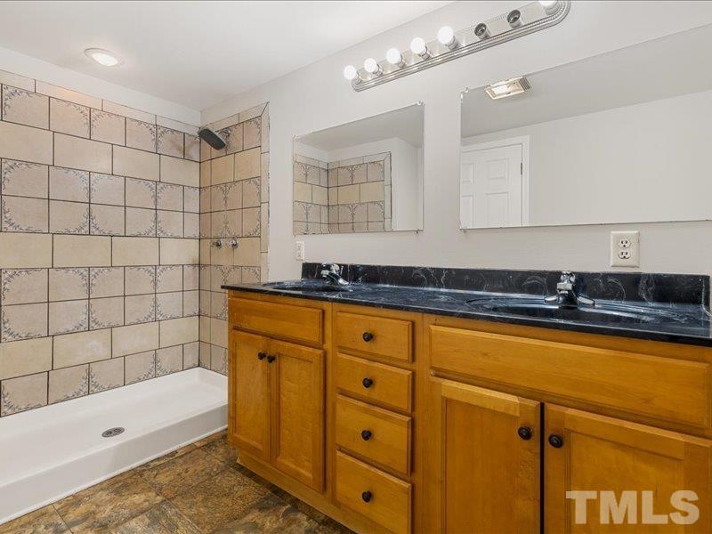 4010 Hurst Drive Franklinton, NC 27525 - Photo 28 of 32 a bathroom with a tub a sink and a mirror