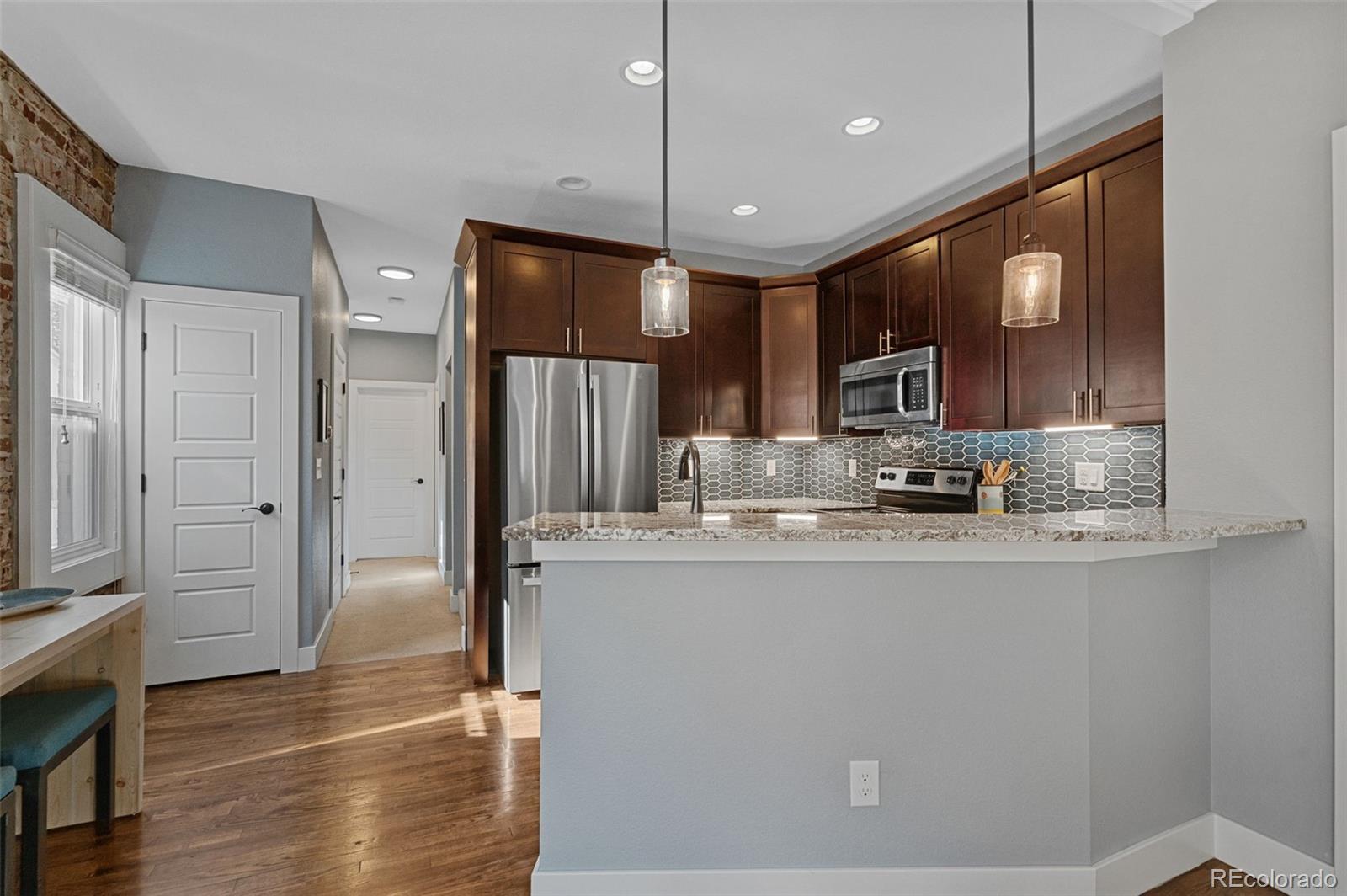 1583 South Ogden Street, Unit 1583 Denver, CO 80210 - Photo 8 of 28 a kitchen with stainless steel appliances granite countertop a refrigerator a sink and a cabinets