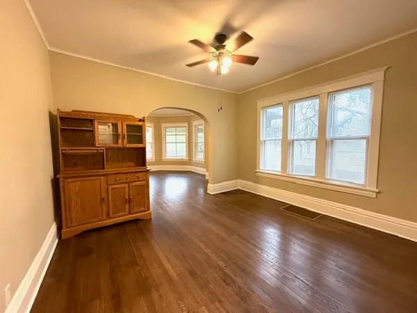 a view of an empty room with a window and wooden floor
