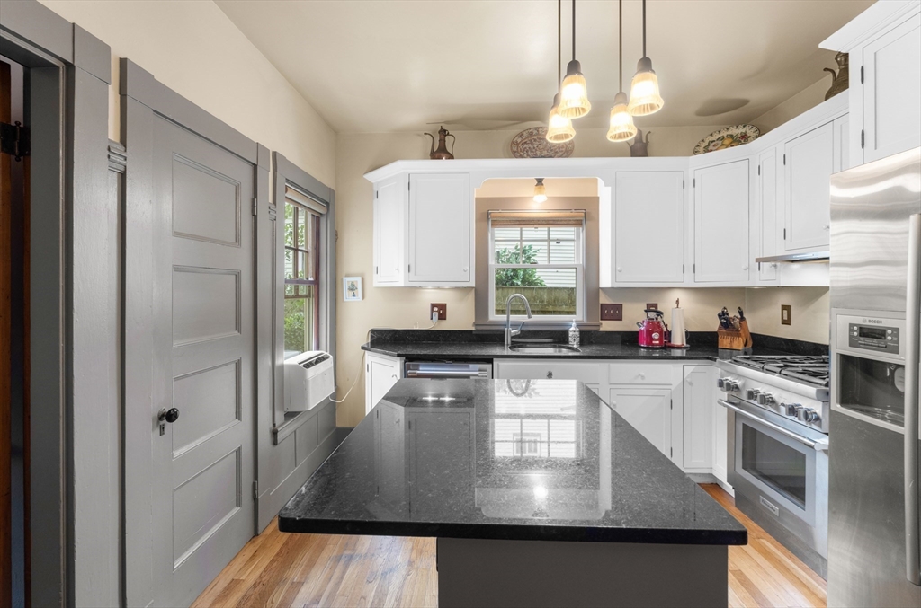 29 Dell Avenue Boston, MA 02136 - Photo 8 of 28 a kitchen with stainless steel appliances granite countertop a stove a refrigerator a sink dishwasher and white cabinets with wooden floor