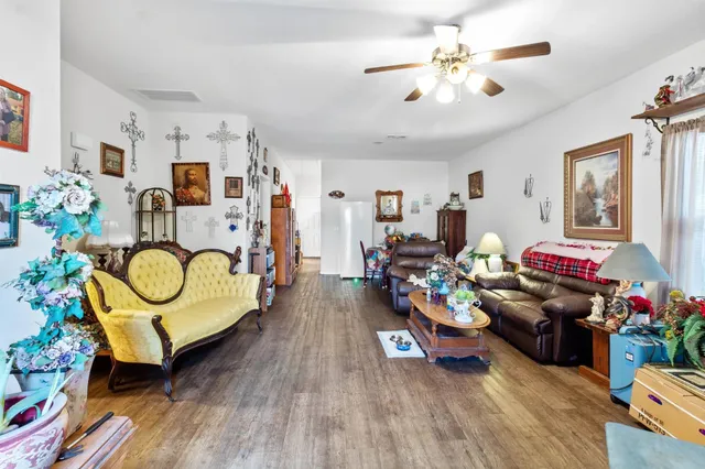 a living room with furniture a chandelier and a wooden floor
