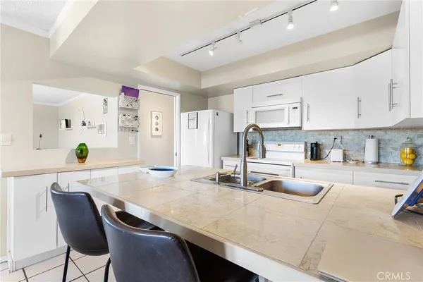 a kitchen with kitchen island a stove sink and cabinets
