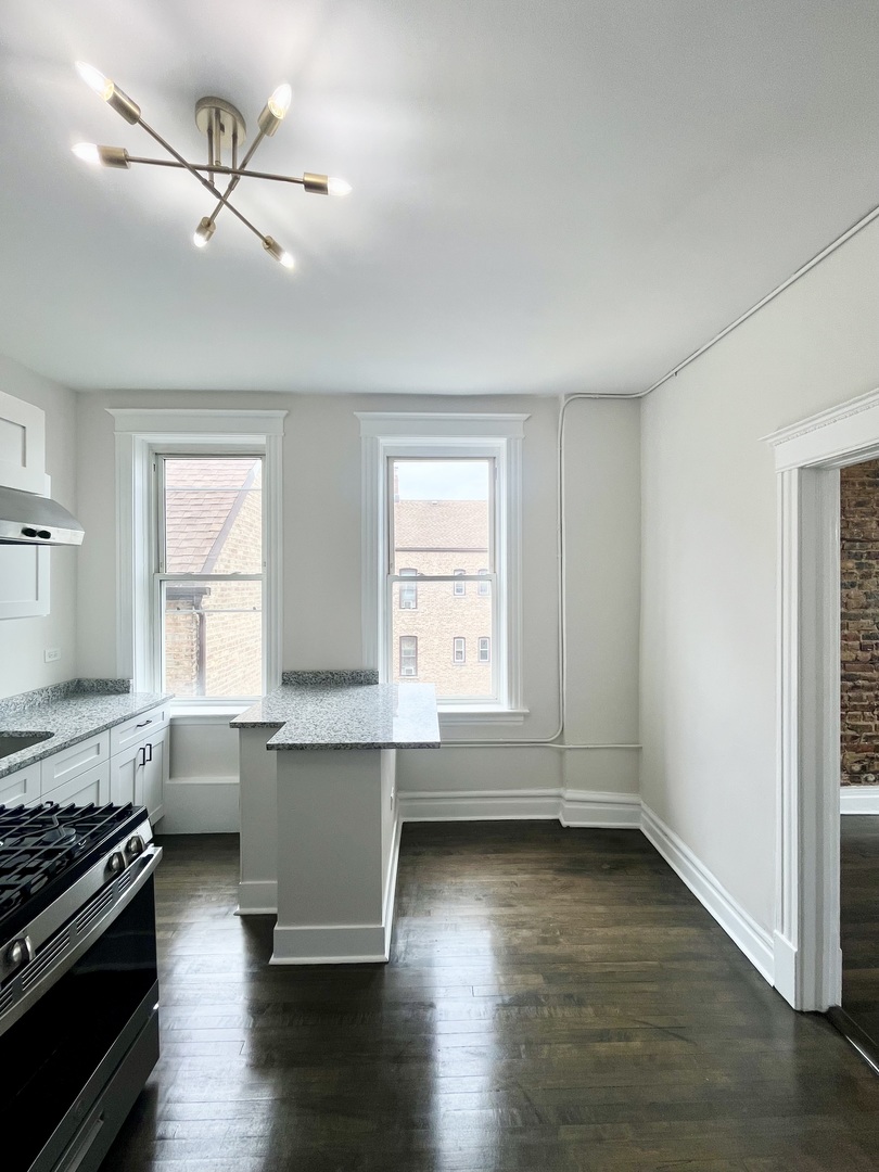 2512 South Trumbull Avenue, Unit 2R Chicago, IL 60623 - Photo 9 of 13 a living room with hard wood floors and a window