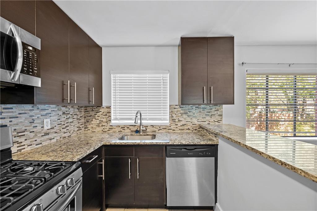 1370 Chalmette Drive Northeast, Unit 2 Atlanta, GA 30306 - Photo 11 of 16 a kitchen with stainless steel appliances granite countertop a sink stove and cabinets