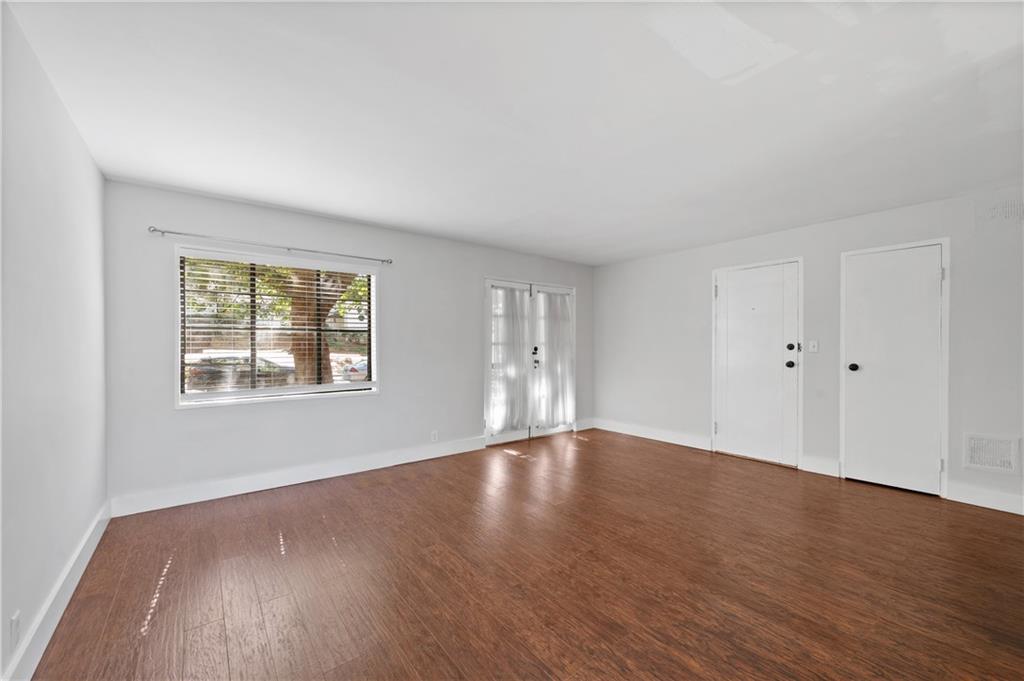 1370 Chalmette Drive Northeast, Unit 2 Atlanta, GA 30306 - Photo 5 of 16 a view of an empty room with wooden floor and a window