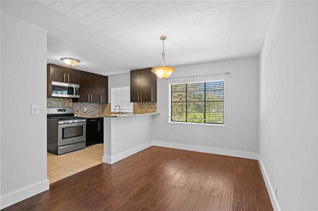 1370 Chalmette Drive Northeast, Unit 2 Atlanta, GA 30306 - Photo 7 of 16 a kitchen with stainless steel appliances granite countertop a stove a sink and a refrigerator