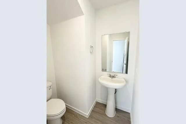 a bathroom with a sink toilet and a mirror