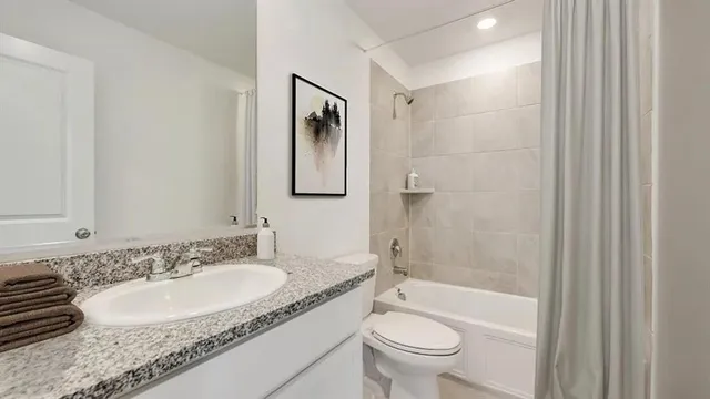 a bathroom with a granite countertop sink toilet and shower
