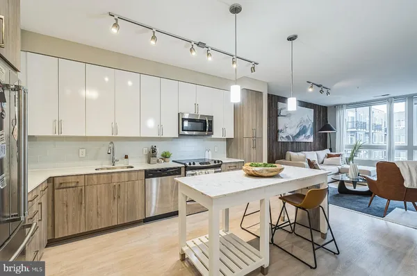 a kitchen with stainless steel appliances granite countertop a stove a sink a microwave a center island and a cabinets